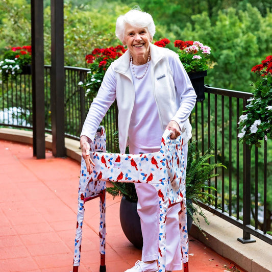 Woman outside showing off the Jover Walker Cover in Winter Birds featuring lively cardinals and festive holly berries on a snowy white background. With pockets and style, it's the perfect winter accessory.