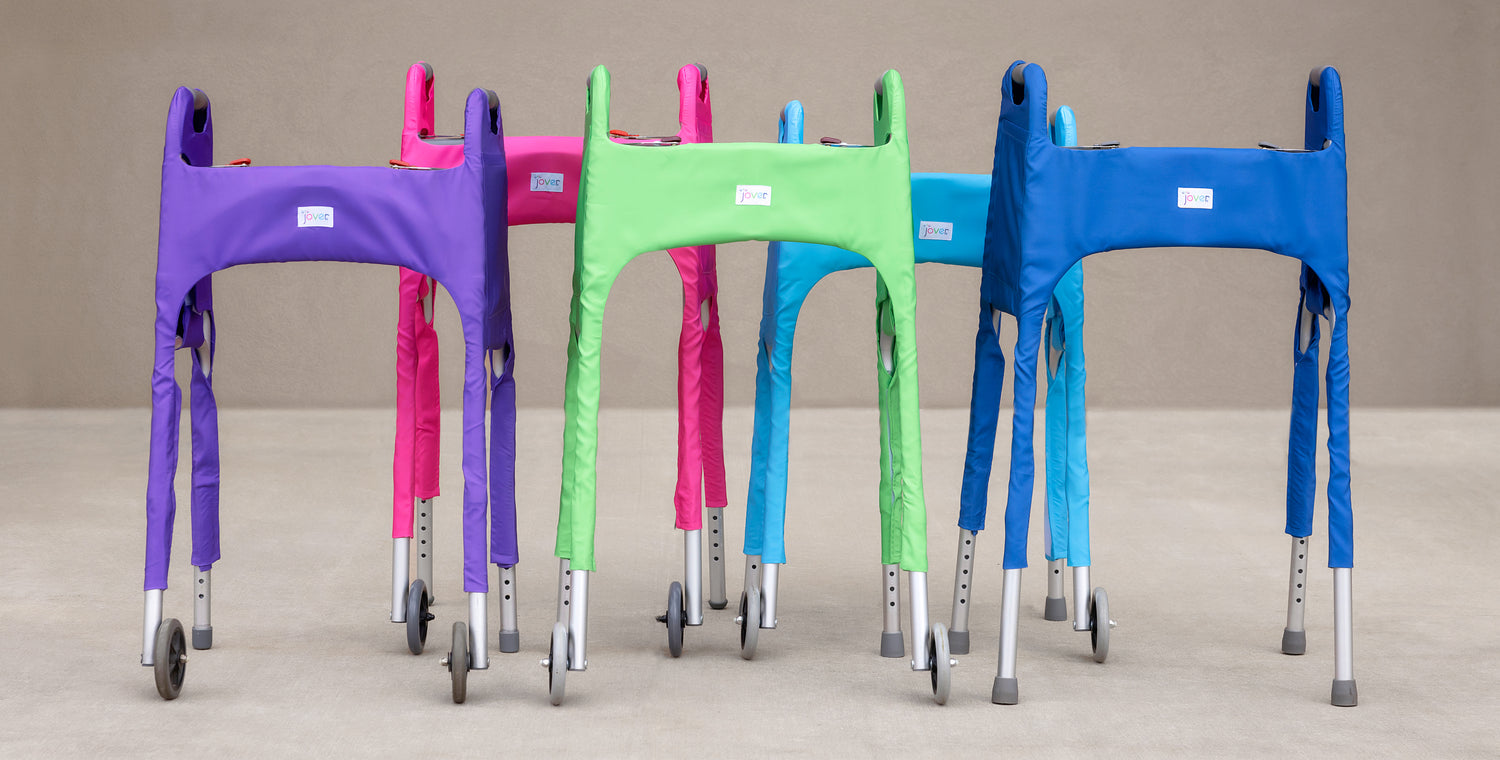 Photo showing a group of five solid-colored Jover Walker Covers on standard folding walkers. Styles are Royally Purple, Spring Meadow (green), Deep Marine (dark blue), Tickled Pink, and Clear Skies (light blue).